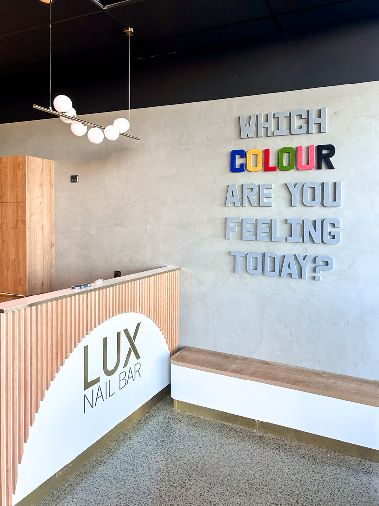 Reception area of a nail salon with bench seating along the wall.  